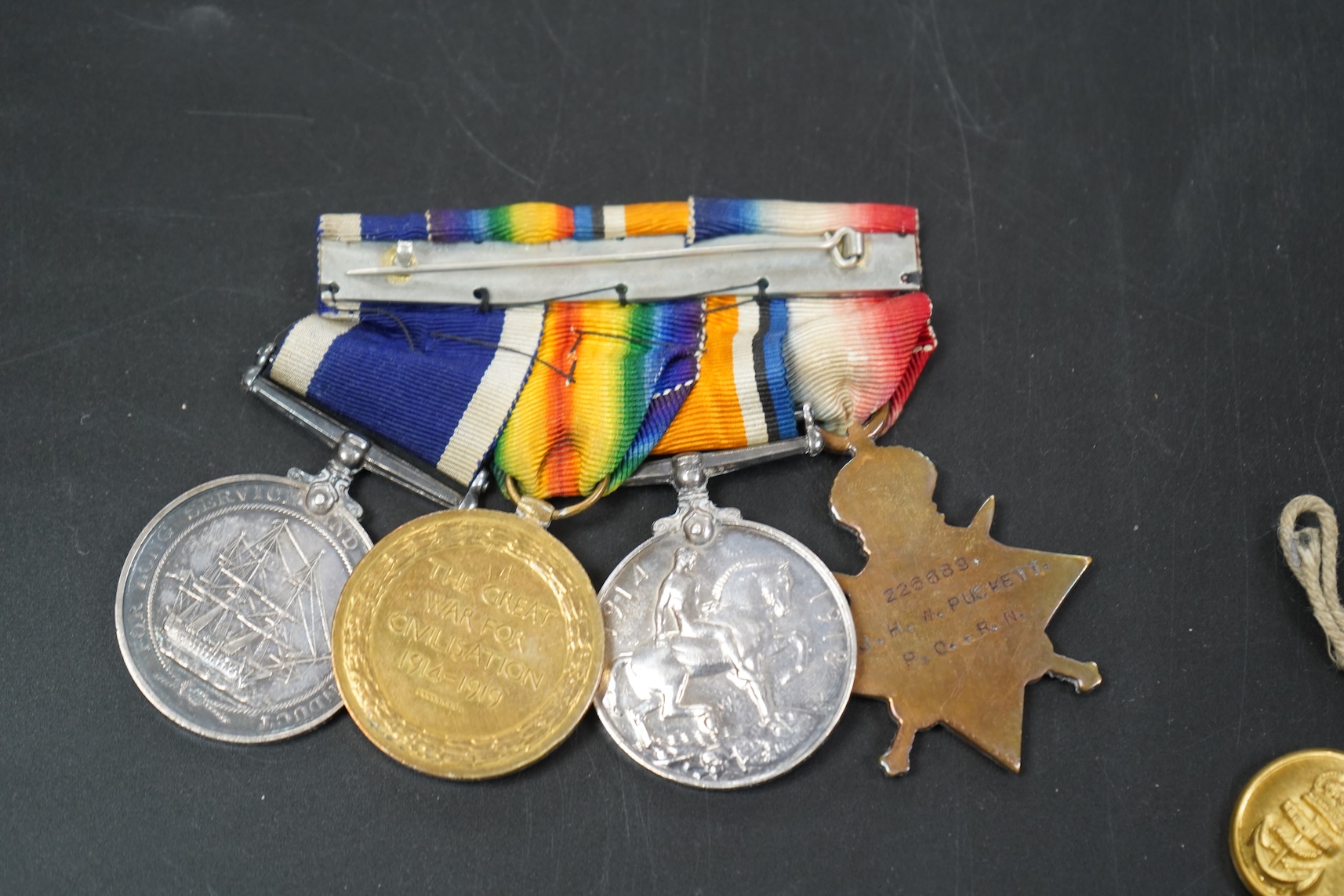 A WWI medal group including Good Conduct awarded to 226989 JHW.PUCKETT.PO.RN. (HMS PEMBROKE) together with cloth badges and a tag